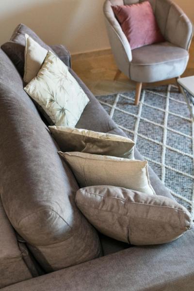 un sofá con almohadas y una silla en la sala de estar. en Royal Cabopino Townhouse, Marbella, en Marbella