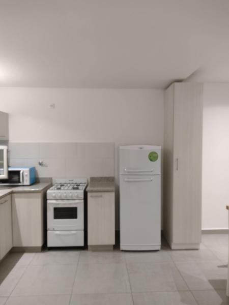 una cocina con electrodomésticos blancos en una habitación en Depto Paz en Tandil