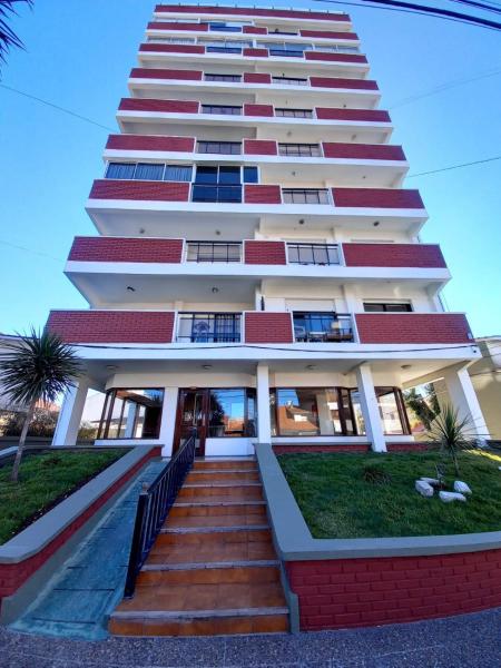 un edificio blanco alto con escaleras delante en Departamentos 3 Ambientes Cochera Punta Mogotes en Mar del Plata