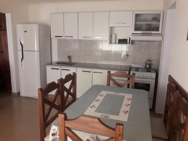 cocina con mesa, sillas y refrigerador en Tandil Centro en Tandil