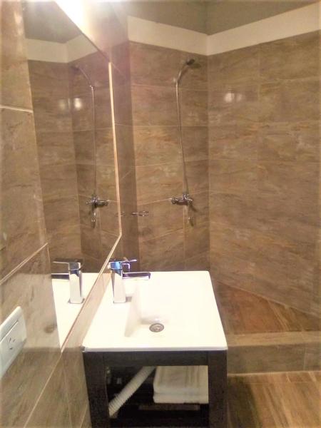 y baño con aseo blanco y ducha.  en Dino´s Hotel en Villa Gesell