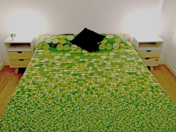 Un dormitorio con una cama verde con una manta verde y blanca en Departamento céntrico y funcional en Buenos Aires