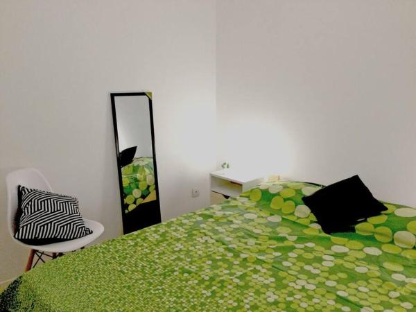 1 dormitorio con cama verde y espejo en Departamento céntrico y funcional en Buenos Aires