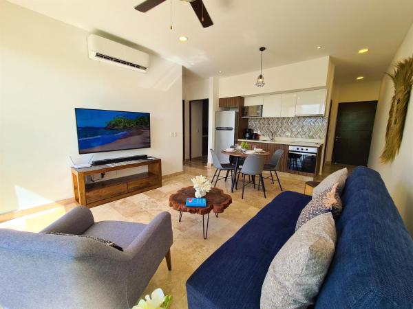 sala de estar con 2 sofás azules y cocina en Comfortable apartment near the beach., en Playa del Carmen