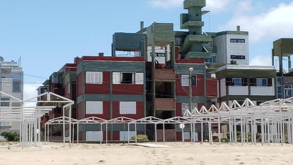 un edificio alto en medio de una ciudad en Villa Gesell Abagú Apartments - Argentina en Villa Gesell