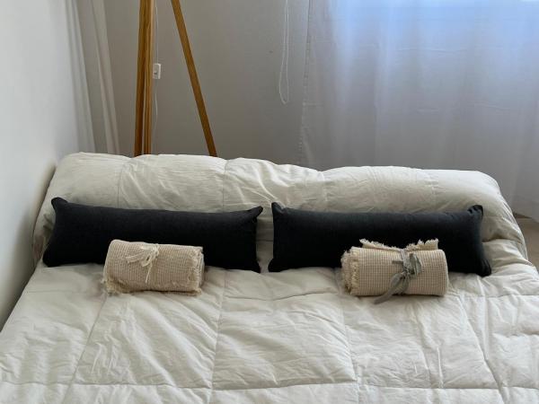 Una cama blanca con dos almohadas. en Meseta en Puerto Madryn