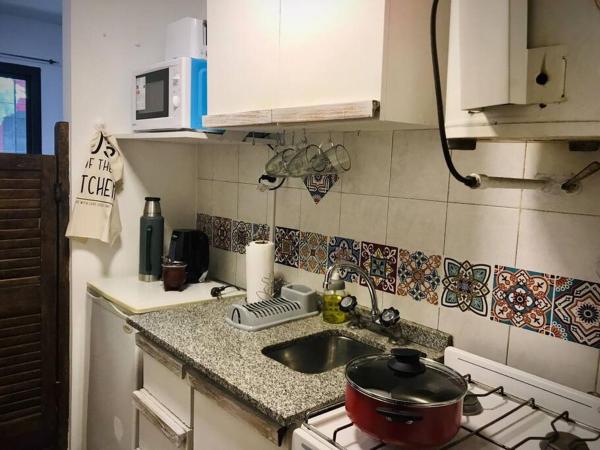 cocina con fregadero y fogones con una olla en la encimera en Hermoso departamento céntrico en Mendoza en Mendoza