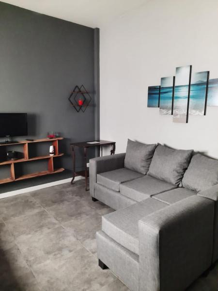 sala de estar con sofá y TV en Departamento Brown - zona centro en Mar del Plata