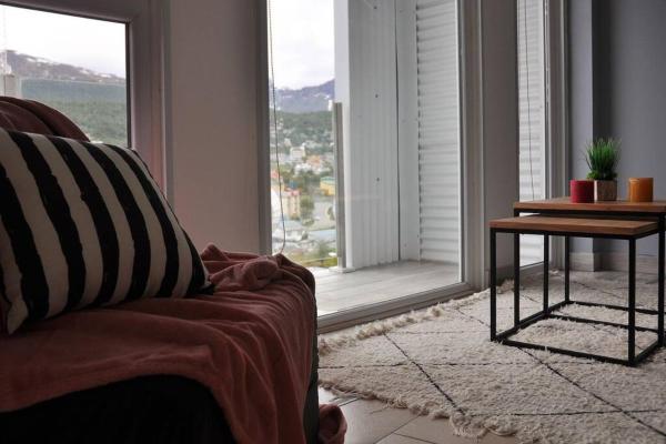 una sala de estar con un sofá y una mesa y una ventana en Altos del Beagle en Ushuaia