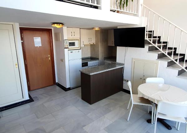 una pequeña cocina con una pequeña mesa y una escalera en Skol 709 Duplex 1 Bedroom in Skol Marbella with Gibraltar and Sea Views, en Marbella