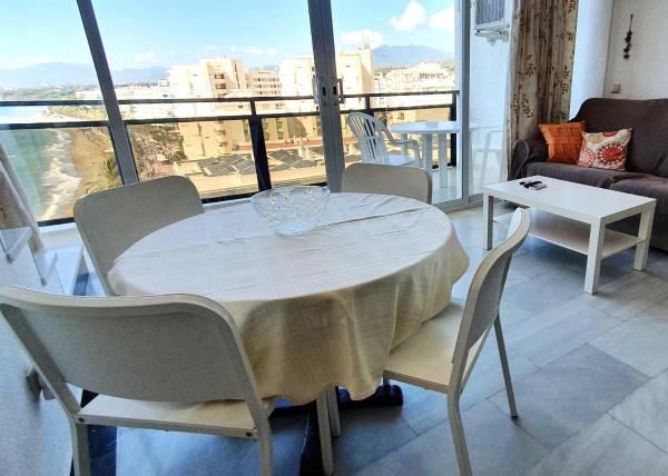 una mesa y sillas blancas en una habitación con ventana en Skol 709 Duplex 1 Bedroom in Skol Marbella with Gibraltar and Sea Views, en Marbella