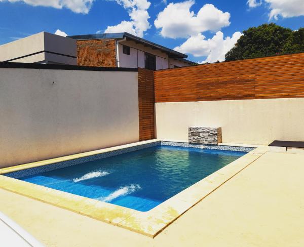 una piscina al lado de una casa en Alojamiento Sol del Iguazú en Puerto Iguazú