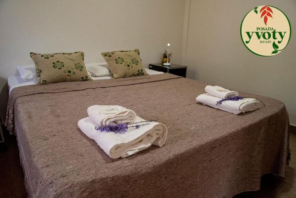 1 dormitorio con 1 cama con toallas en Posada Yvoty en Puerto Iguazú