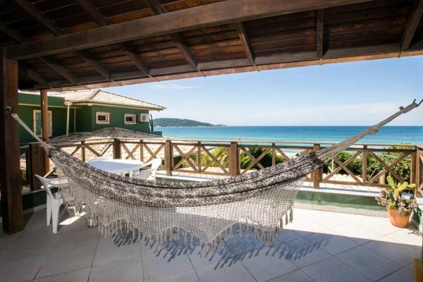 a hammock on a patio overlooking the ocean at Campeche Beach House in Florianópolis