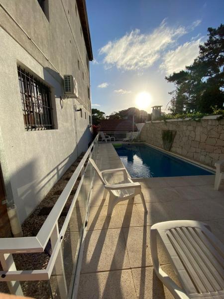 un patio con 2 sillas y una piscina en El Horreo Apart en Villa Gesell