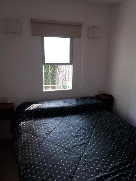 1 dormitorio con 1 cama frente a una ventana en valle encantado en Pinamar