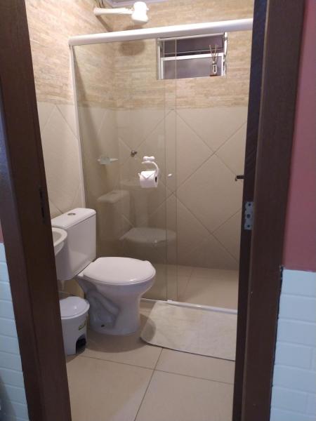 a bathroom with a toilet and a shower stall at Aeropouso Pousada Executiva in Florianópolis