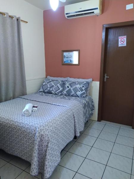 a bedroom with a bed and a dresser at Aeropouso Pousada Executiva in Florianópolis
