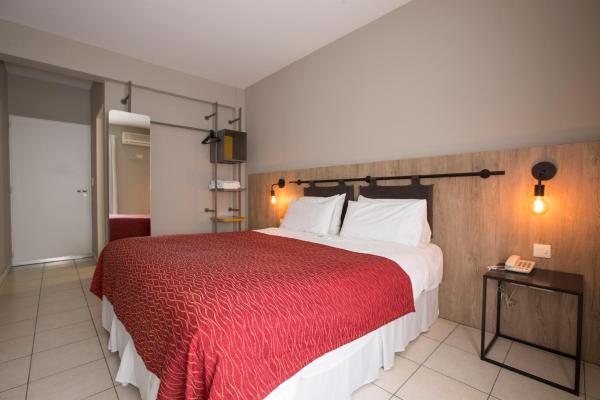 1 dormitorio con 1 cama grande con manta roja en Boutique Apartments Plaza Dorrego en Buenos Aires