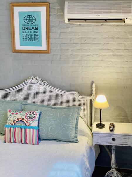 Un dormitorio con una cama blanca y una lámpara en una mesa en VIAJERO Suites & Hostel Punta del este, en Punta del Este