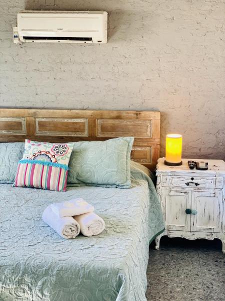 Una cama con toallas y una lámpara en una mesa. en VIAJERO Suites & Hostel Punta del este, en Punta del Este