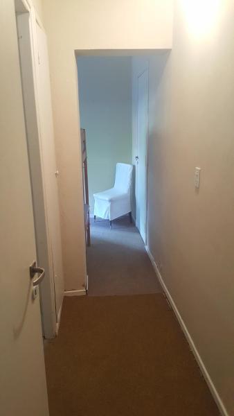 un pasillo con una silla blanca en una habitación del Hotel Norte de Villa Gesell