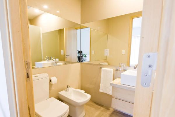 y baño con aseo, lavabo y espejo. en Le Montreal Apart Hotel en Mendoza