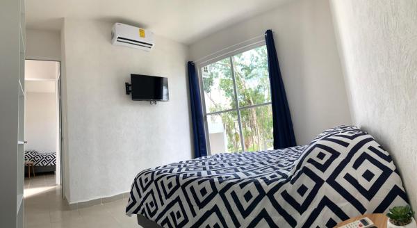 1 dormitorio con cama y ventana al Departamento 2 habitaciones con vista a la piscina by EITA, en Cancún