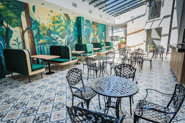 un restaurante con mesas y sillas y un mural en Garden Suites Pinamar en Pinamar