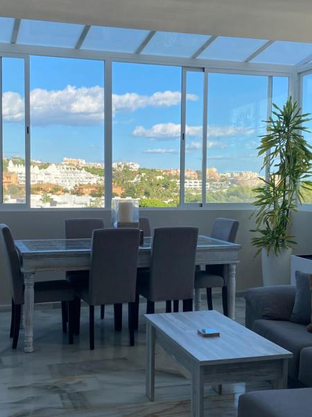 comedor con mesa y sillas y ventana grande en Paradise Penthouse on the Mediterranean, en Estepona