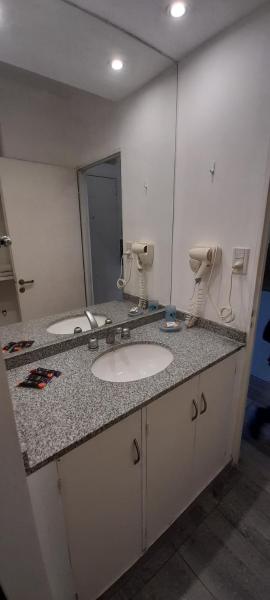 y baño con lavabo y espejo. en Departamento temporario en Salta la Linda en Salta