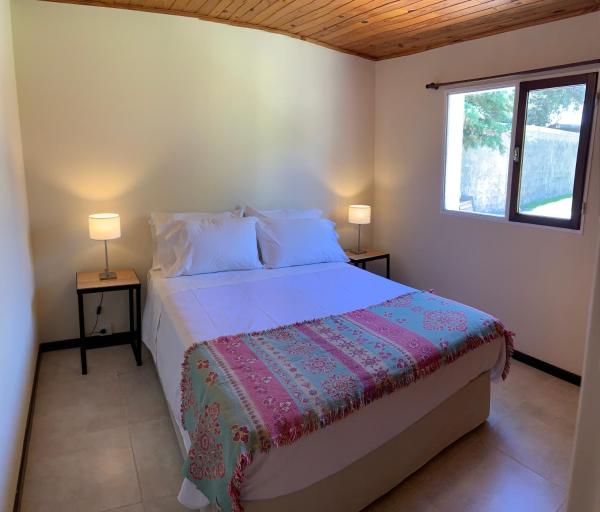 1 dormitorio con 1 cama con 2 lámparas en 2 mesas en Las Rucas en San Martín de los Andes