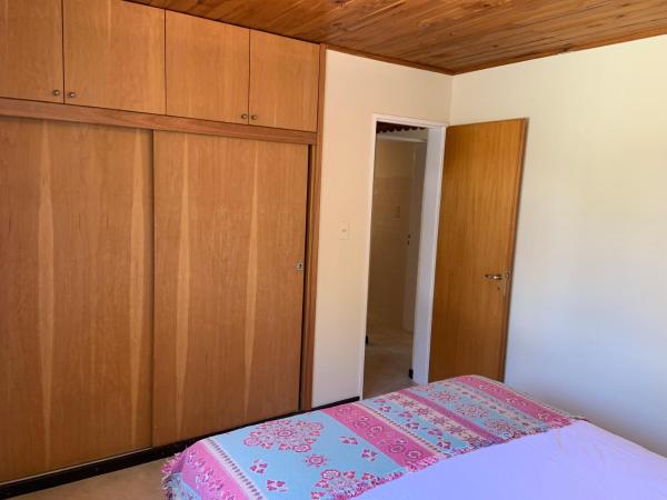 1 dormitorio con 1 cama y armarios de madera en Las Rucas en San Martín de los Andes
