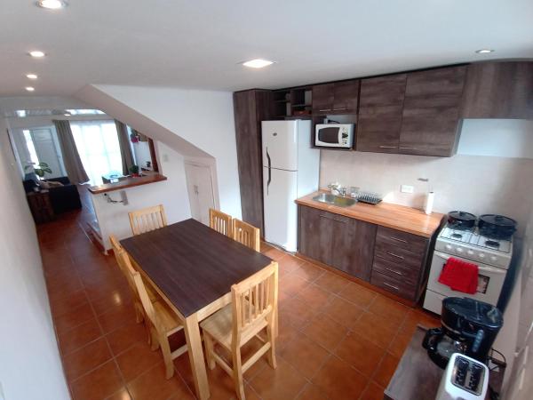 cocina con mesa, sillas y refrigerador en Temporarios Don Valdés en Puerto Madryn