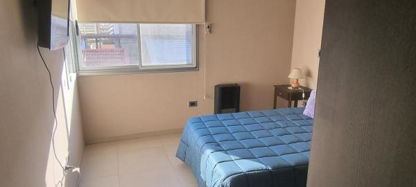 Un dormitorio con una cama azul y una ventana en Edificio quinta sur 3 en Mendoza