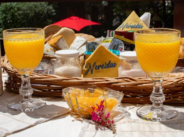 dos vasos de zumo de naranja y una cesta de pan.  en Nereidas Aparte en Mar de las Pampas