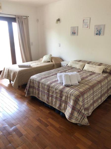 2 camas en una habitación con suelo de madera en Departamento zona residencial CON PILETA en Salta
