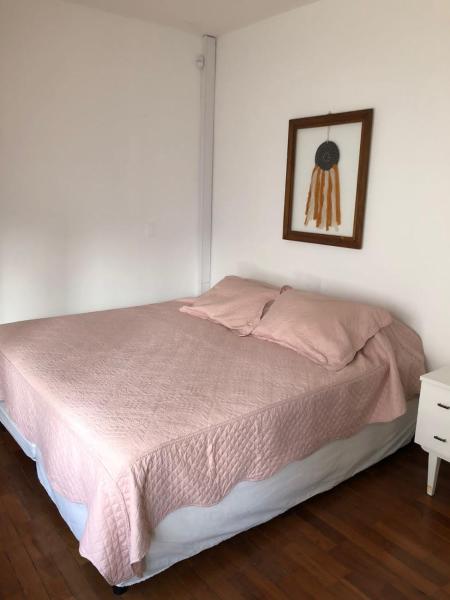 Un dormitorio con una cama rosa con una foto en la pared en Departamento zona residencial CON PILETA en Salta