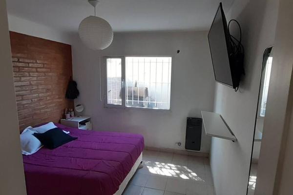 1 dormitorio con cama morada y ventana en 7 GIRASOLES a 4 cuadras del mar en Puerto Madryn