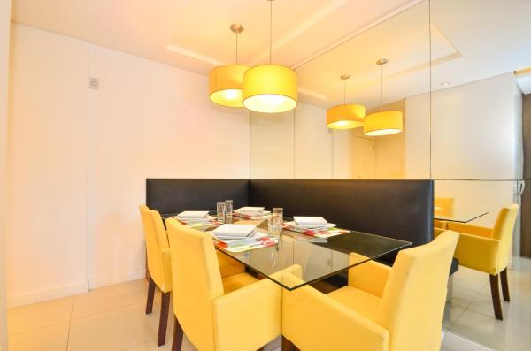 a dining room with a glass table and yellow chairs at Jurerê para 6 hóspedes a 2 quadras da praia N1705 in Florianópolis
