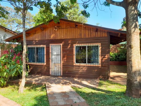 una pequeña casa de madera con árboles delante en Voces De La Selva Misionera en Puerto Iguazú