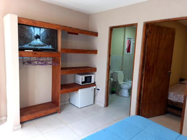 Habitación con cama, TV y baño. en Apart Hotel El Faro en Ostende