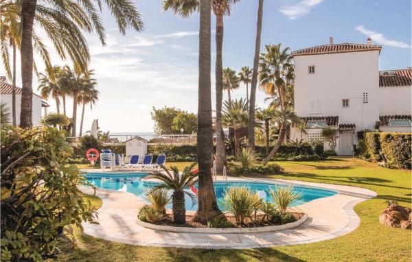 una piscina con palmeras frente a una casa en Stunning apartment in Marbella with 3 Bedrooms, WiFi and Outdoor swimming pool, en Marbella