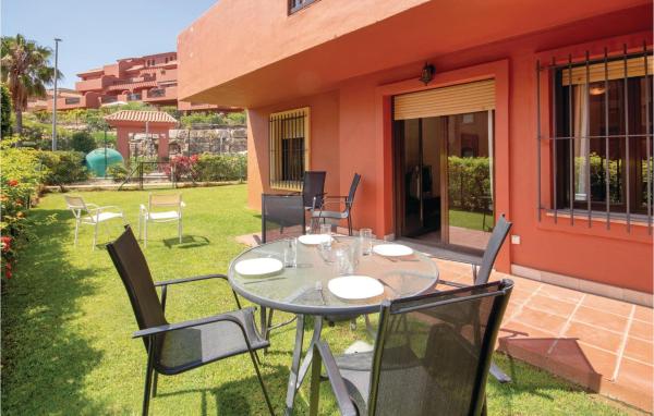 un patio con mesa y sillas en la gespa en Precioso apartamento en Estepona con 3 habitaciones, piscina exterior y piscina, en Estepona