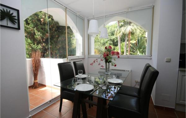 comedor con mesa de cristal y sillas negras en Stunning apartment in Marbella-Las Chapas with 2 Bedrooms, WiFi and Outdoor swimming pool, en Marbella