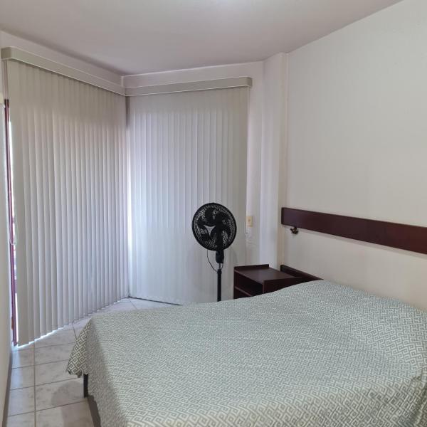 a bedroom with a bed and a fan at Estúdio Estrela do Mar in Florianópolis