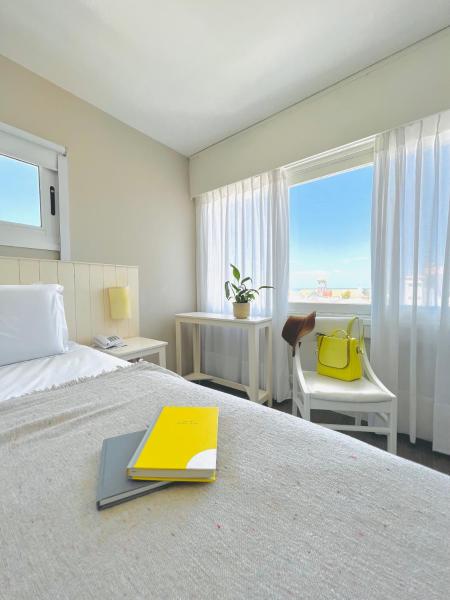 una habitación de hotel con una cama con un libro encima en Atlántico Boutique Hotel, en Punta del Este