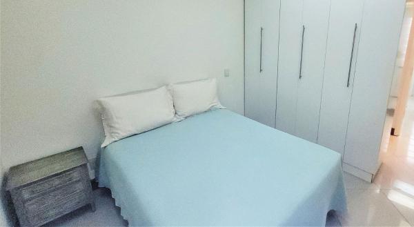 1 dormitorio pequeño con 1 cama azul y 2 almohadas en Ótimo quarto e sala em área nobre do Leblon, en Río de Janeiro