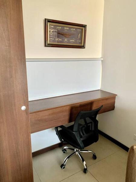 un escritorio con una silla sentada bajo una pared en Golden Hour Studio - Dos Orillas 404, en Colonia del Sacramento