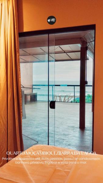 a sliding glass door with a view of the ocean at Graffi Beach Hostel in Florianópolis